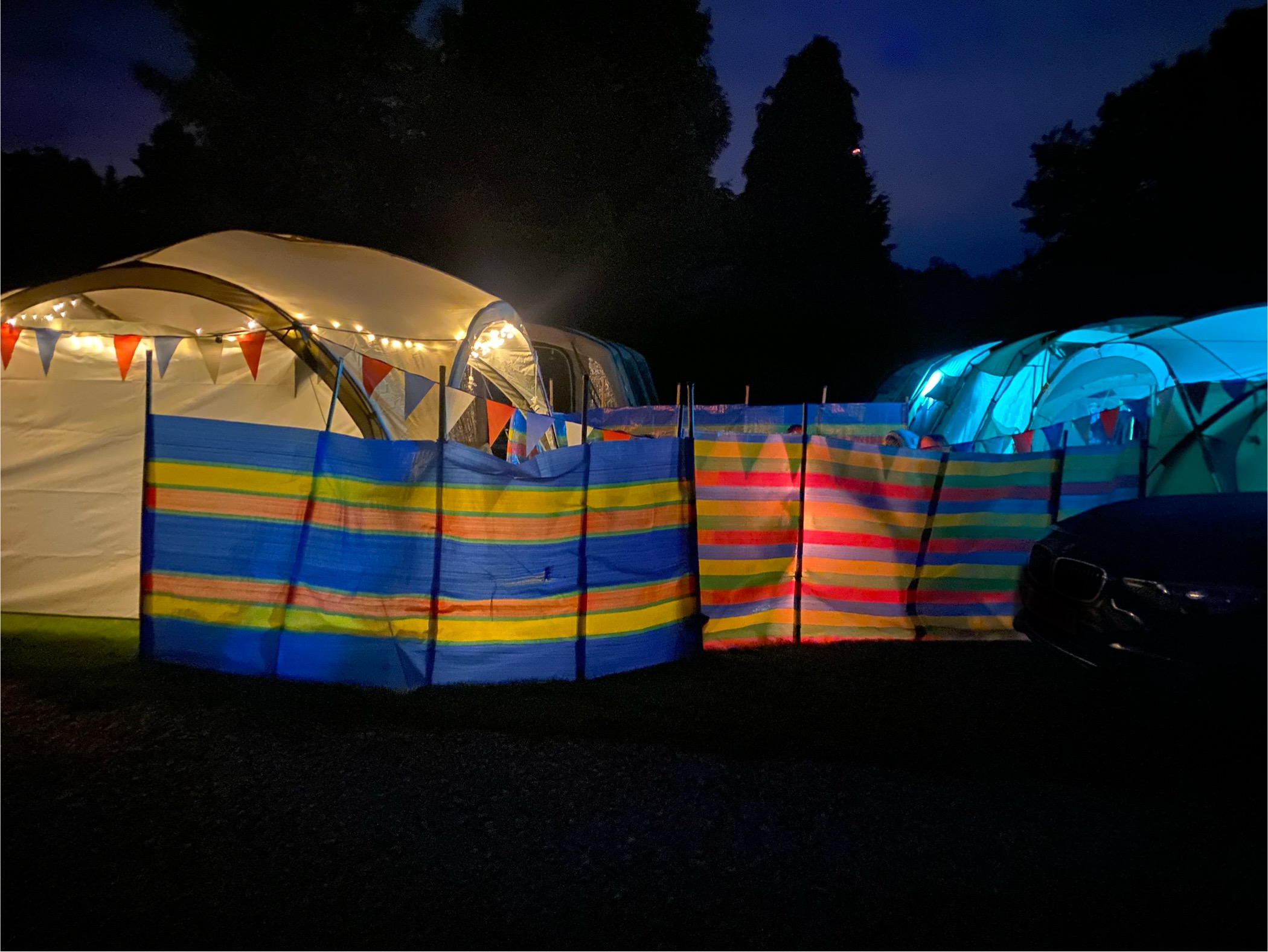 Illuminated tents with wind breakers and bunting